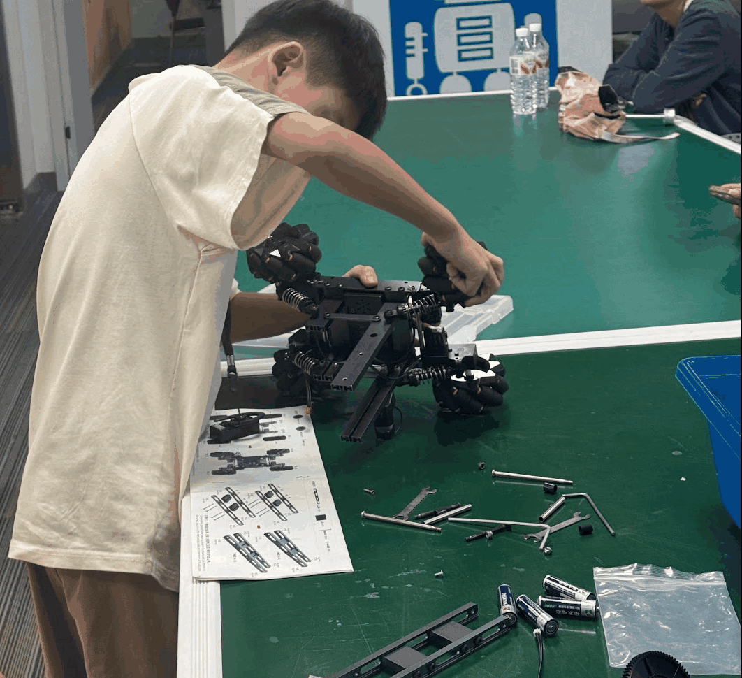 Student assembling an industrial robot model